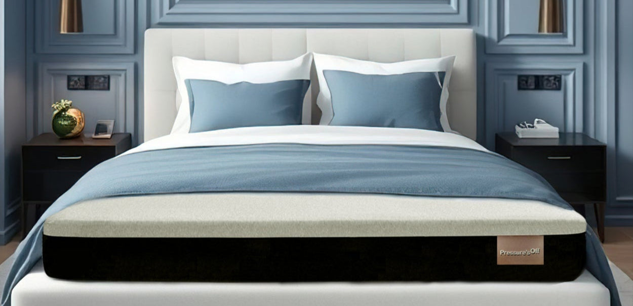 Modern bedroom with blue walls, white bed, and wooden furniture. Pressure's Off mattress for pain relief is featured.